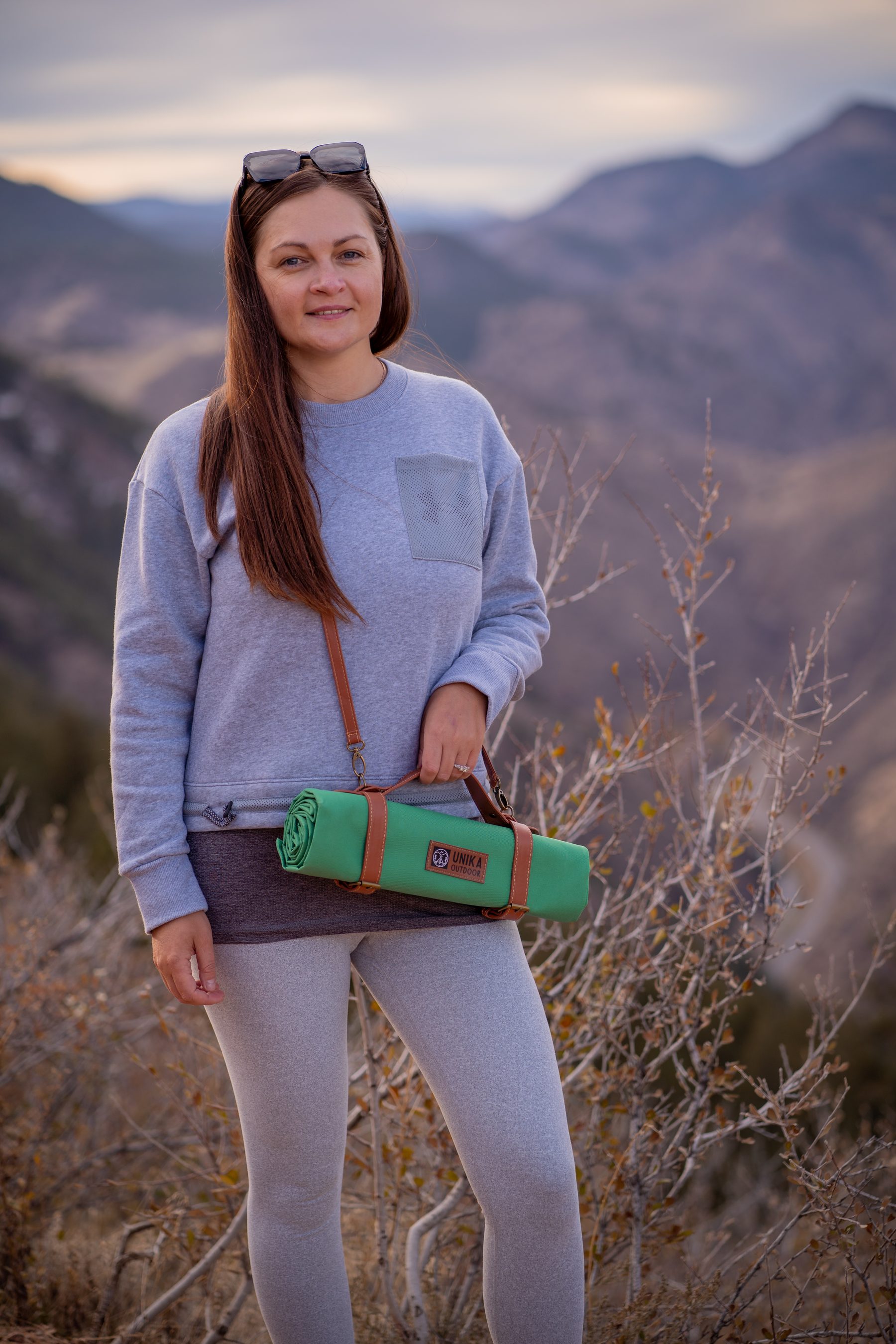 Model wearing a green UNIKA picnic blanket