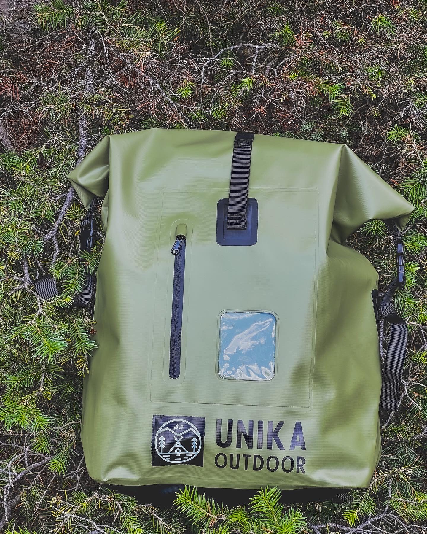 UNIKA green waterproof backpack on forest floor